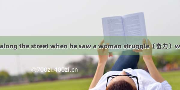 A man was walking along the street when he saw a woman struggle（奋力）with a large box. It wa